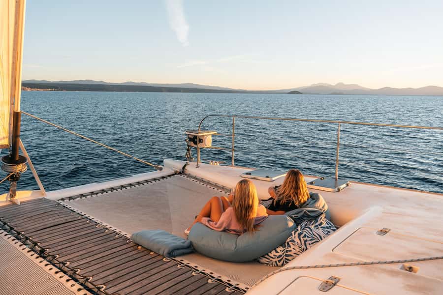 Lake Taupo: Luxury Sailing Catamaran to Māori Rock Carvings - Sailing back with a drink and a blanket