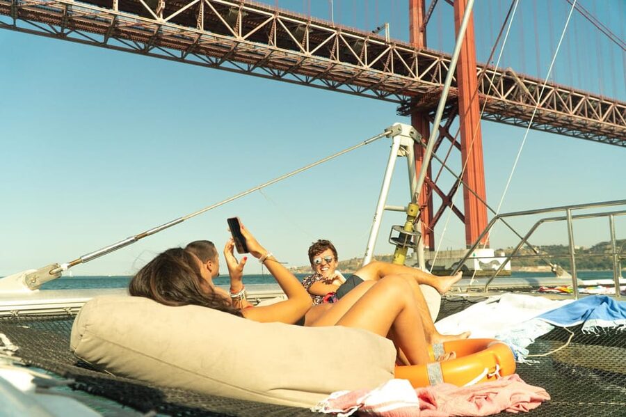 Lisbon: Catamaran Boat Party with Music, Open Bar & Dives - Cruising toward Algés