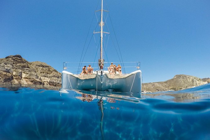Santorini Catamaran Cruise with Fresh Meal and Open Bar - Red Beach, where the cliffs turn rust red