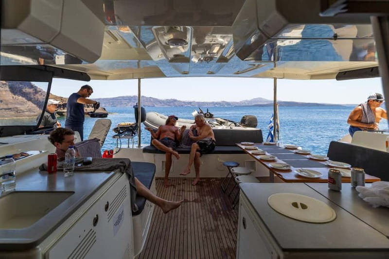 Santorini: Catamaran Cruise with Fresh Meal & Open Bar - Returning to Red Beach and watching the sunset
