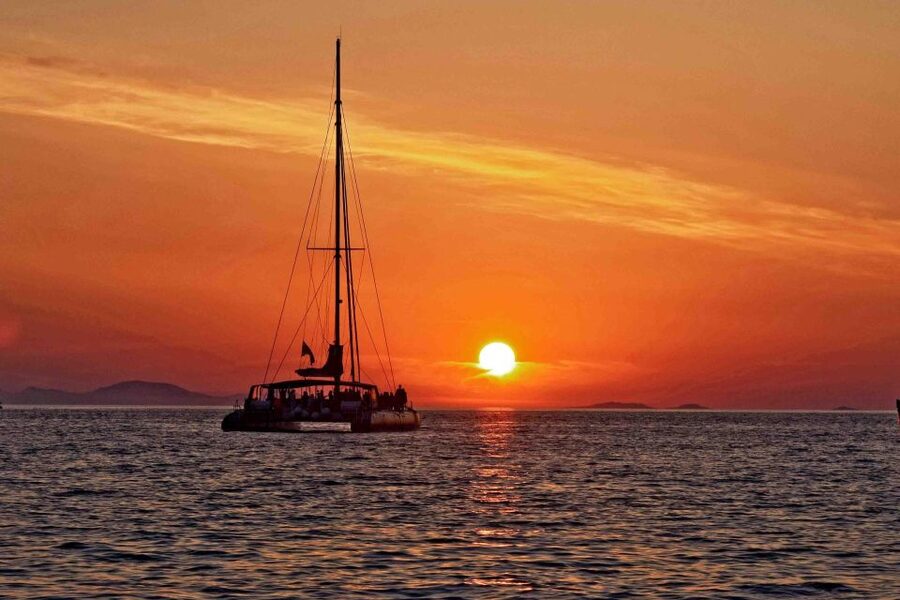 Santorini: Cruise Catamaran with BBQ & Drinks Day or Sunset - Red Beach: swimming beside volcanic rock