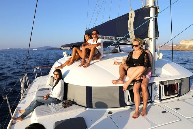 Santorini Half Day Catamaran Private Cruise incl. Meal, Drinks & Free Transport - The lighthouse and the lonely shape of Aspronisi