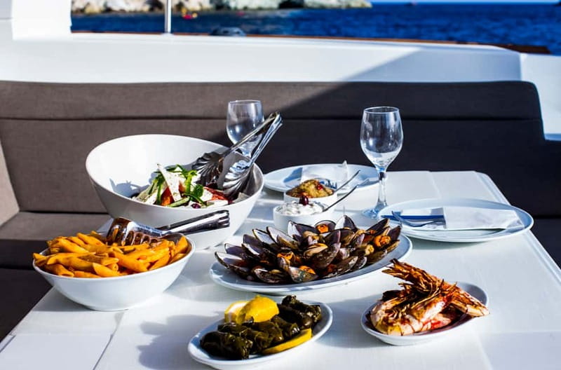 Santorini: Private Catamaran Cruise with BBQ Meal and Drinks - Caves, cliffs, and Fira Old Port from the water